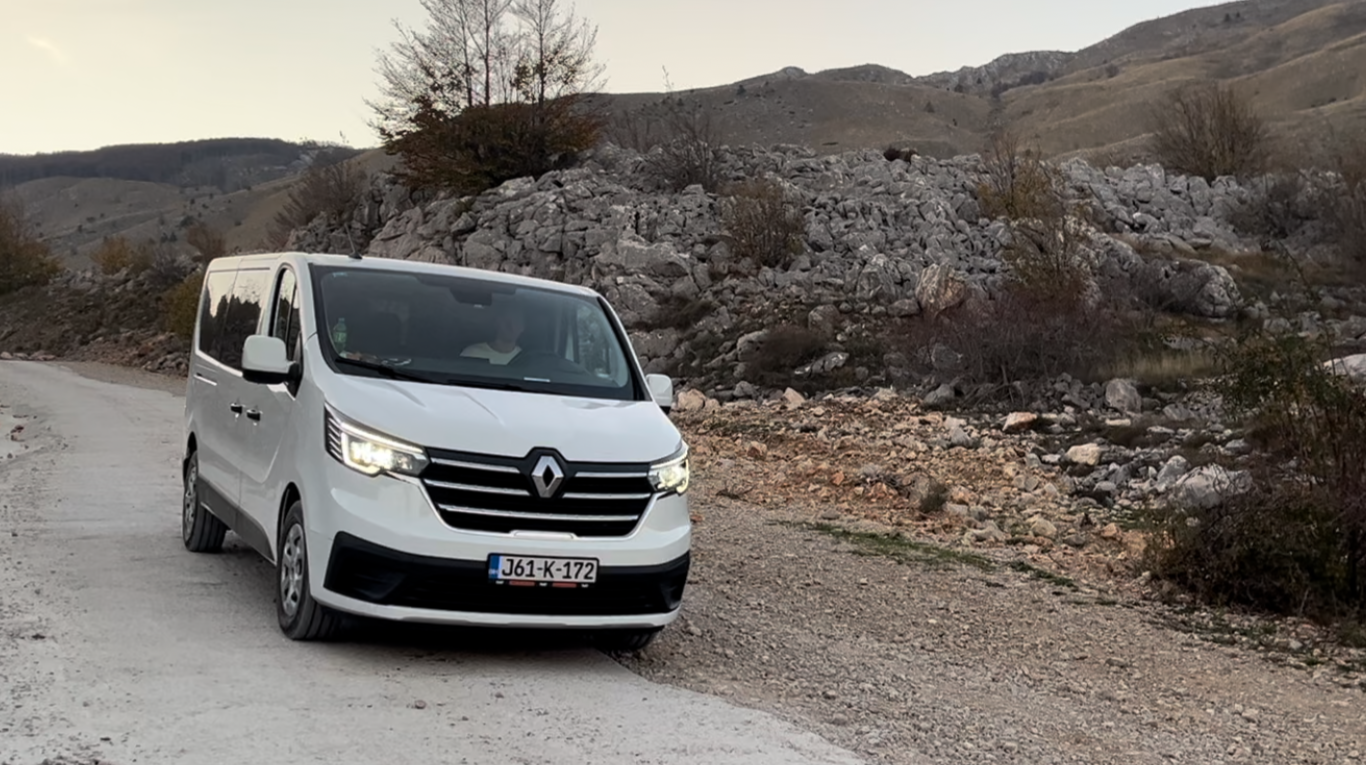 White van driving on a dirt road